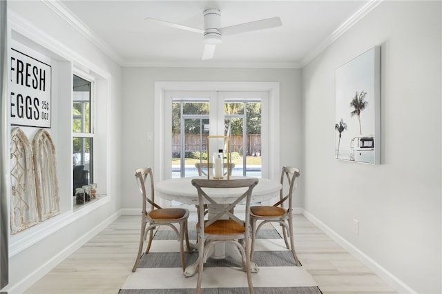 dining room with baseboards, plenty of natural light, ornamental molding, and light wood-style flooring