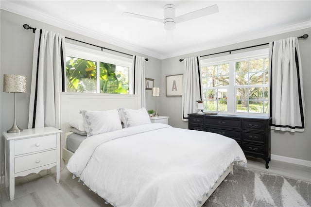 bedroom featuring baseboards, multiple windows, ornamental molding, and a ceiling fan