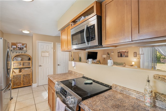 kitchen with light tile patterned floors and stainless steel appliances