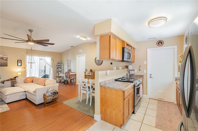 kitchen with ceiling fan, stainless steel appliances, lofted ceiling, and light wood-type flooring