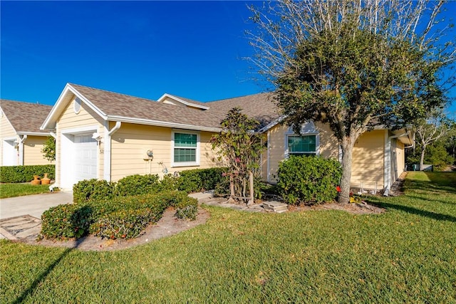 ranch-style house featuring a garage and a front lawn