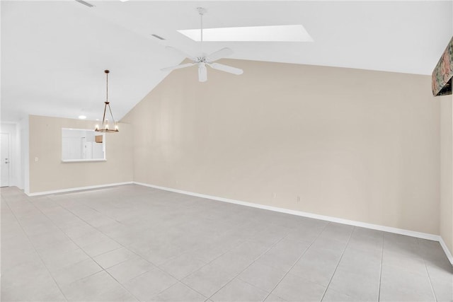 unfurnished room featuring lofted ceiling with skylight, ceiling fan with notable chandelier, and light tile patterned floors