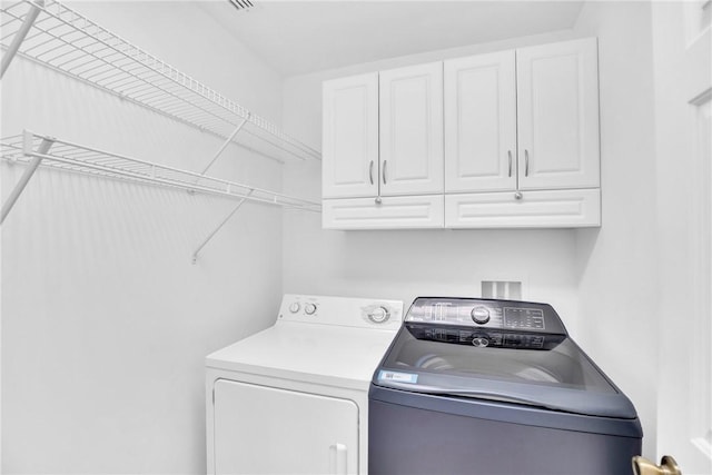 laundry room featuring cabinets and separate washer and dryer