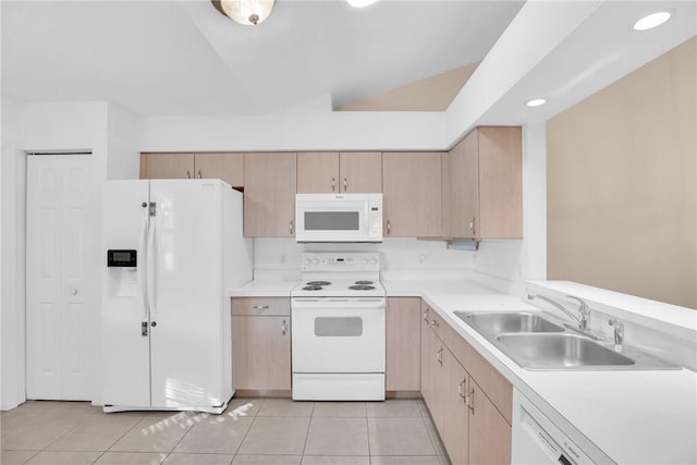 kitchen with light tile patterned flooring, white appliances, sink, and light brown cabinets