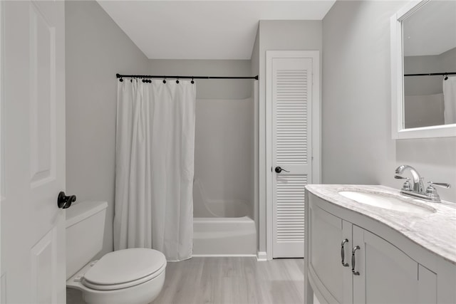 full bathroom with hardwood / wood-style flooring, vanity, toilet, and shower / tub combo