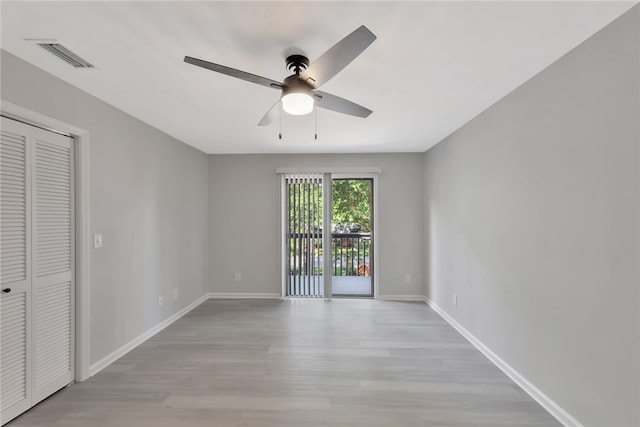 unfurnished bedroom featuring ceiling fan, a closet, light hardwood / wood-style flooring, and access to outside