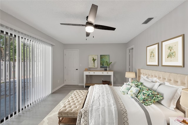 bedroom with access to outside, light hardwood / wood-style floors, a textured ceiling, and ceiling fan