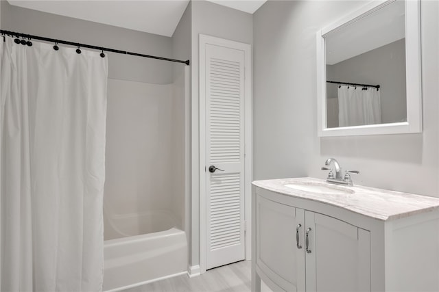 bathroom featuring hardwood / wood-style floors, vanity, and shower / bath combo with shower curtain