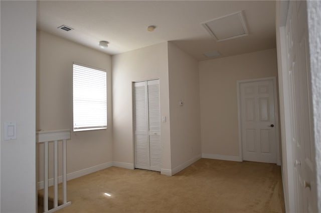 unfurnished bedroom featuring a closet and light colored carpet