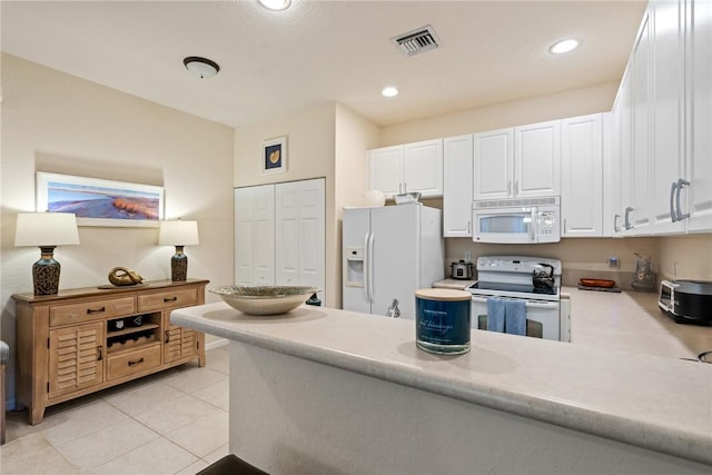 kitchen with white appliances, white cabinetry, kitchen peninsula, and light tile patterned floors