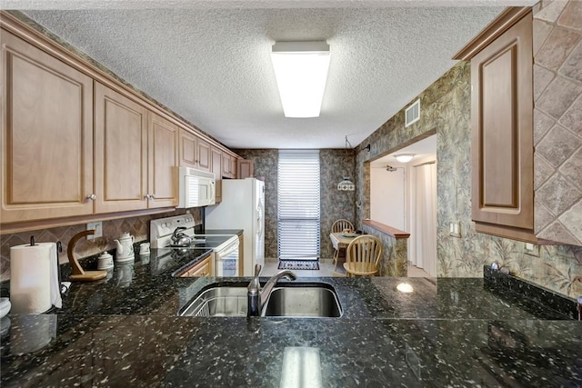 1480 Ocean Dr Unit 4C, Vero Beach, FL 32963 - kitchen featuring white appliances, a textured ceiling, dark stone countertops, and decorative backsplash