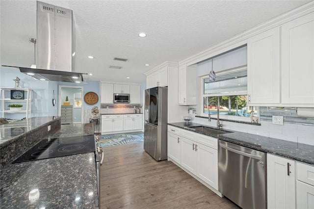 kitchen featuring a textured ceiling, stainless steel appliances, white cabinets, dark stone counters, and sink