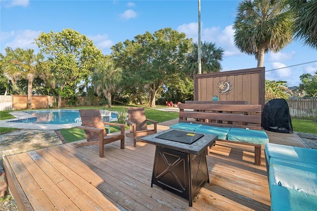 wooden deck featuring an outdoor living space with a fire pit, area for grilling, and a fenced in pool