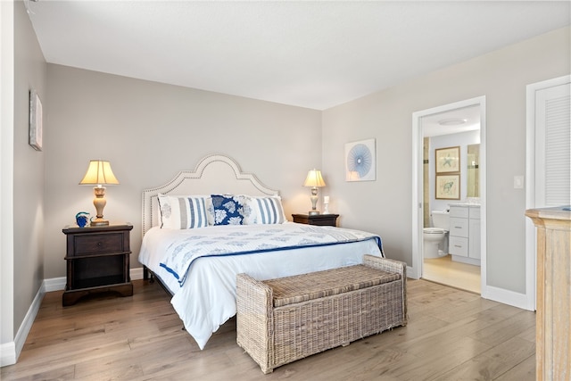 bedroom featuring connected bathroom and hardwood / wood-style floors