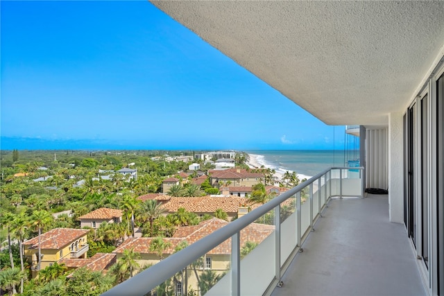 balcony featuring a water view and a beach view