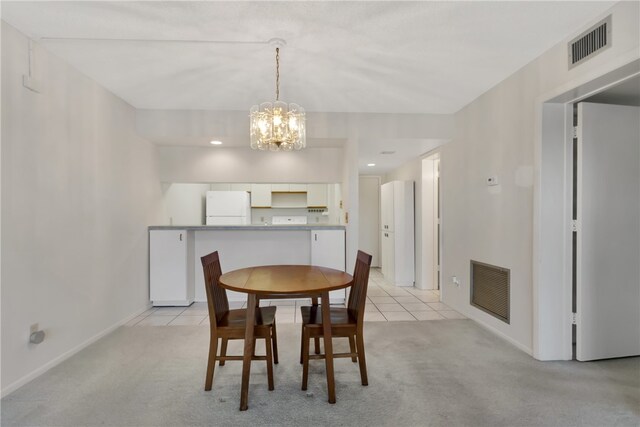 carpeted dining room with an inviting chandelier