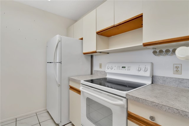 kitchen with white appliances, white cabinetry, and light tile patterned flooring