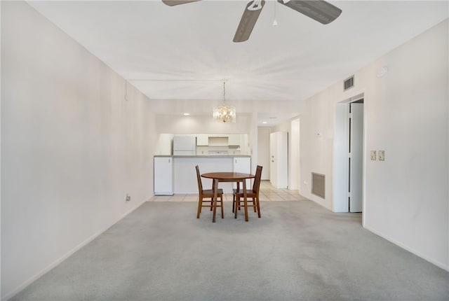 carpeted dining room featuring ceiling fan with notable chandelier