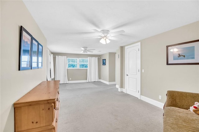 unfurnished living room featuring light carpet and ceiling fan