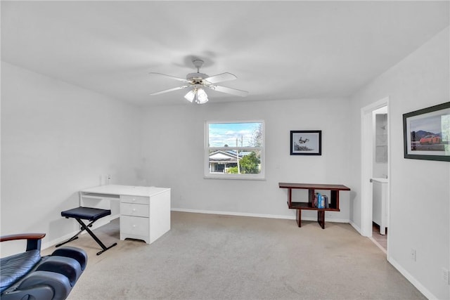 carpeted home office featuring ceiling fan