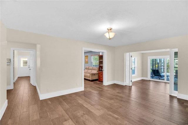 empty room featuring a healthy amount of sunlight and hardwood / wood-style floors