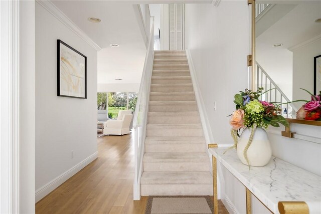 stairway featuring baseboards, wood finished floors, and recessed lighting