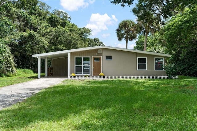 view of front of home with a front yard and a carport