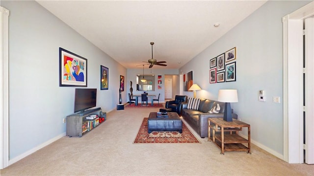 carpeted living room with ceiling fan