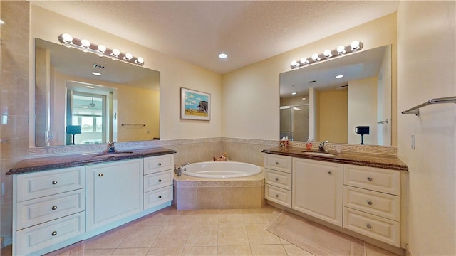 bathroom with tile patterned floors, separate shower and tub, vanity, and a textured ceiling