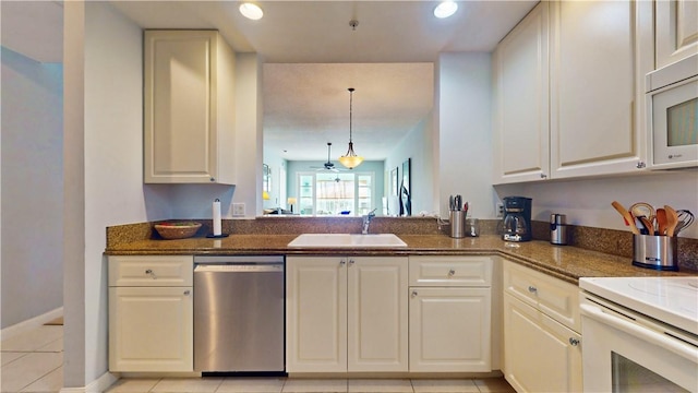 kitchen with sink, hanging light fixtures, light tile patterned floors, white appliances, and white cabinets