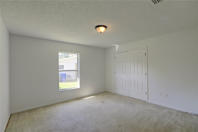 carpeted spare room featuring a textured ceiling