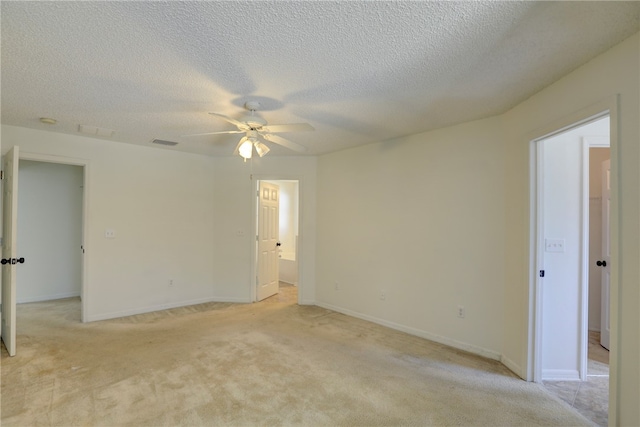 empty room featuring a textured ceiling, light colored carpet, and ceiling fan