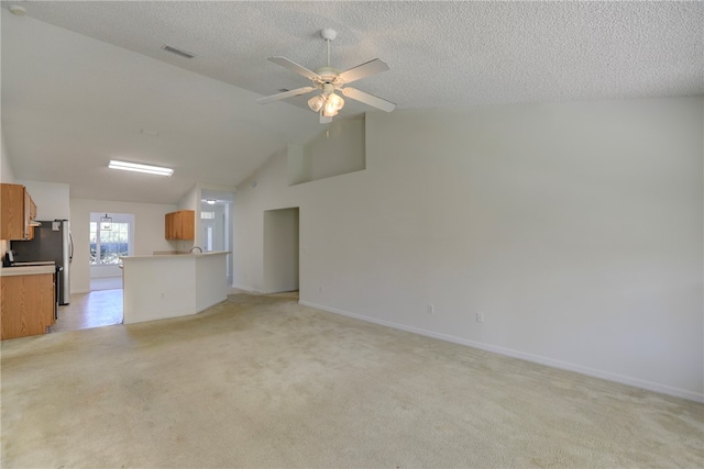 unfurnished living room with vaulted ceiling, light colored carpet, and ceiling fan