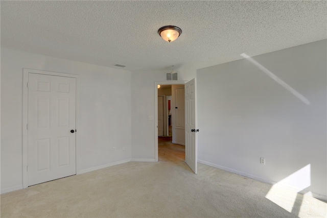 bonus room featuring light colored carpet and a textured ceiling