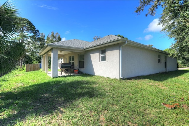 back of property featuring a patio and a lawn