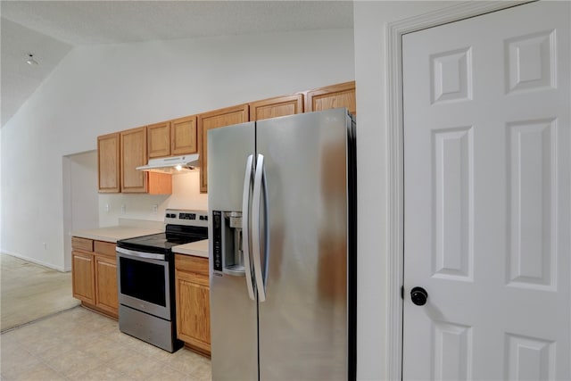 kitchen featuring vaulted ceiling, light brown cabinetry, and appliances with stainless steel finishes