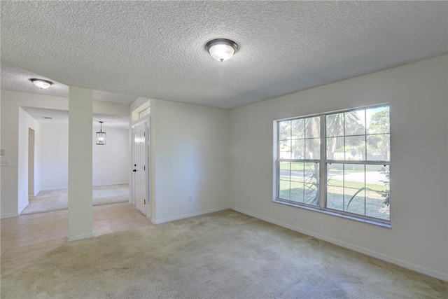 empty room with a textured ceiling and light carpet