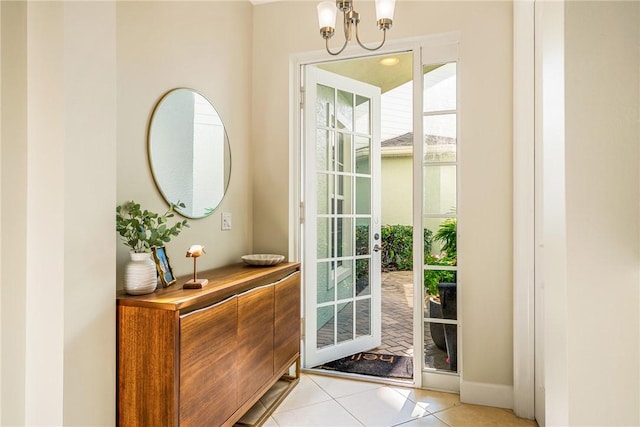 doorway to outside featuring a notable chandelier and light tile patterned floors