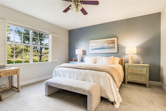 bedroom featuring multiple windows, ceiling fan, and light carpet