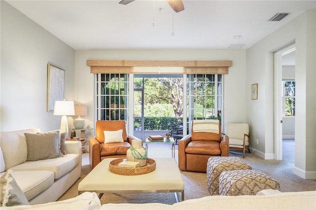 carpeted living room with ceiling fan