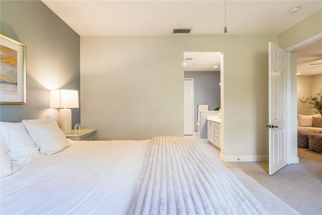 bedroom with light carpet and ensuite bath