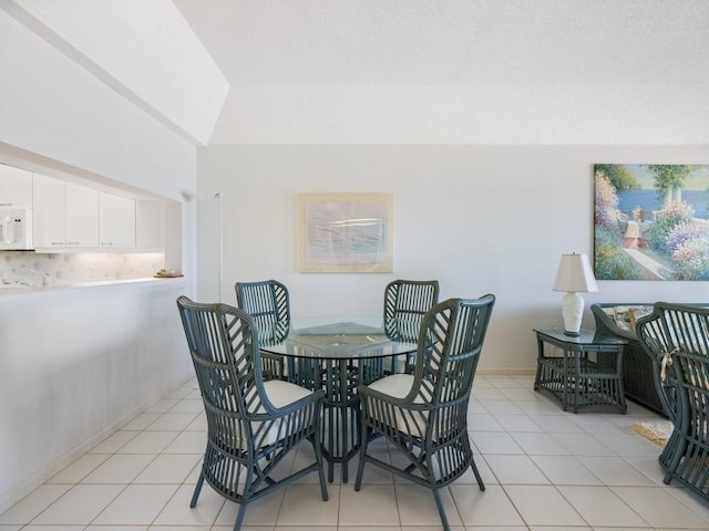 dining space with baseboards and light tile patterned flooring