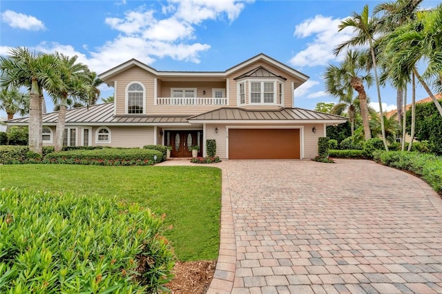 view of front facade featuring a garage, a front lawn, and french doors