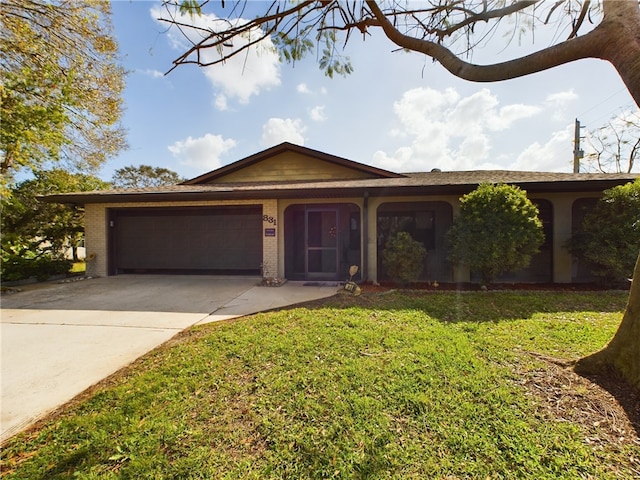 ranch-style house featuring a garage and a front lawn