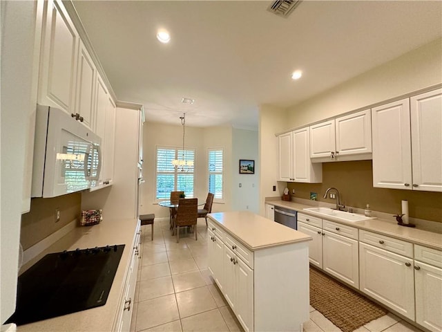 kitchen featuring light tile patterned floors, white microwave, visible vents, a sink, and dishwasher