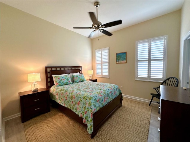 bedroom featuring multiple windows, baseboards, and ceiling fan