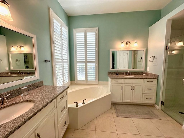 full bathroom featuring a sink, a garden tub, a shower stall, and tile patterned flooring