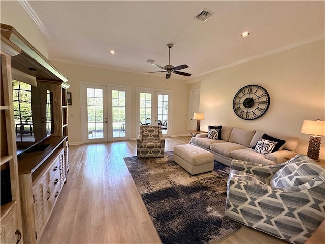 living area featuring visible vents, plenty of natural light, french doors, and ornamental molding