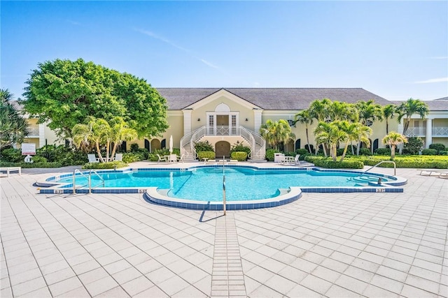 community pool featuring stairs and a patio