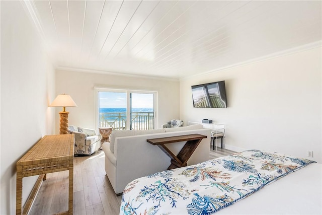 bedroom featuring wood finished floors, ornamental molding, and access to outside